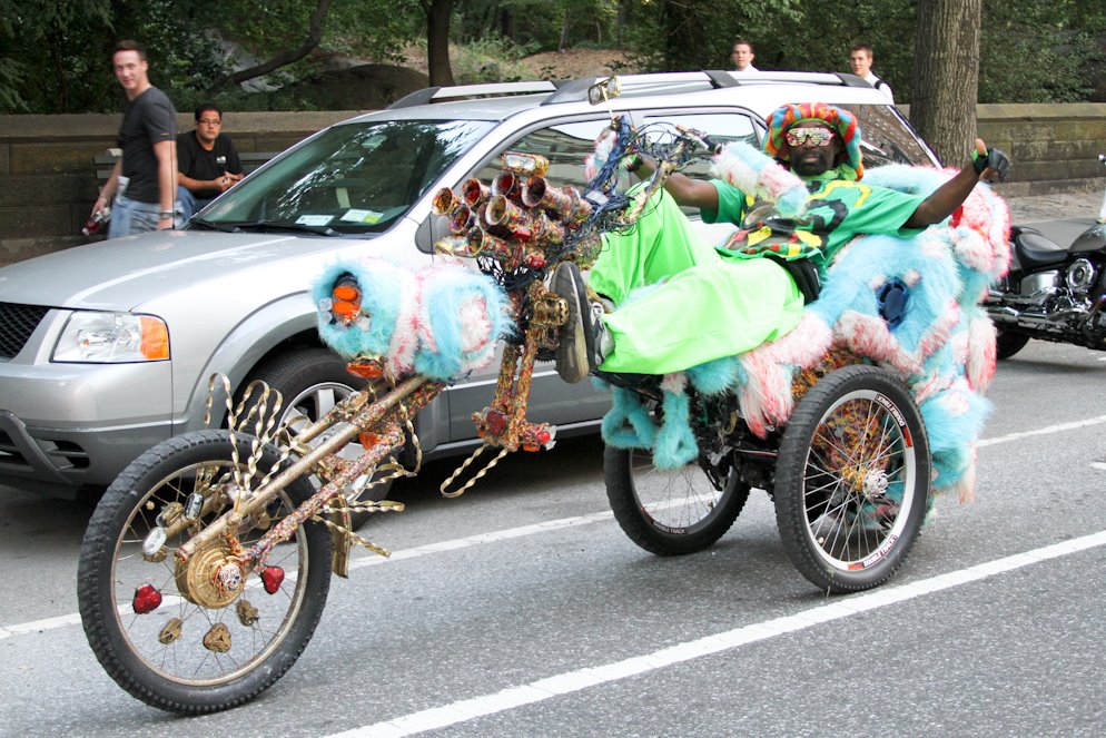 Lavishly dressed man on three-wheel bike