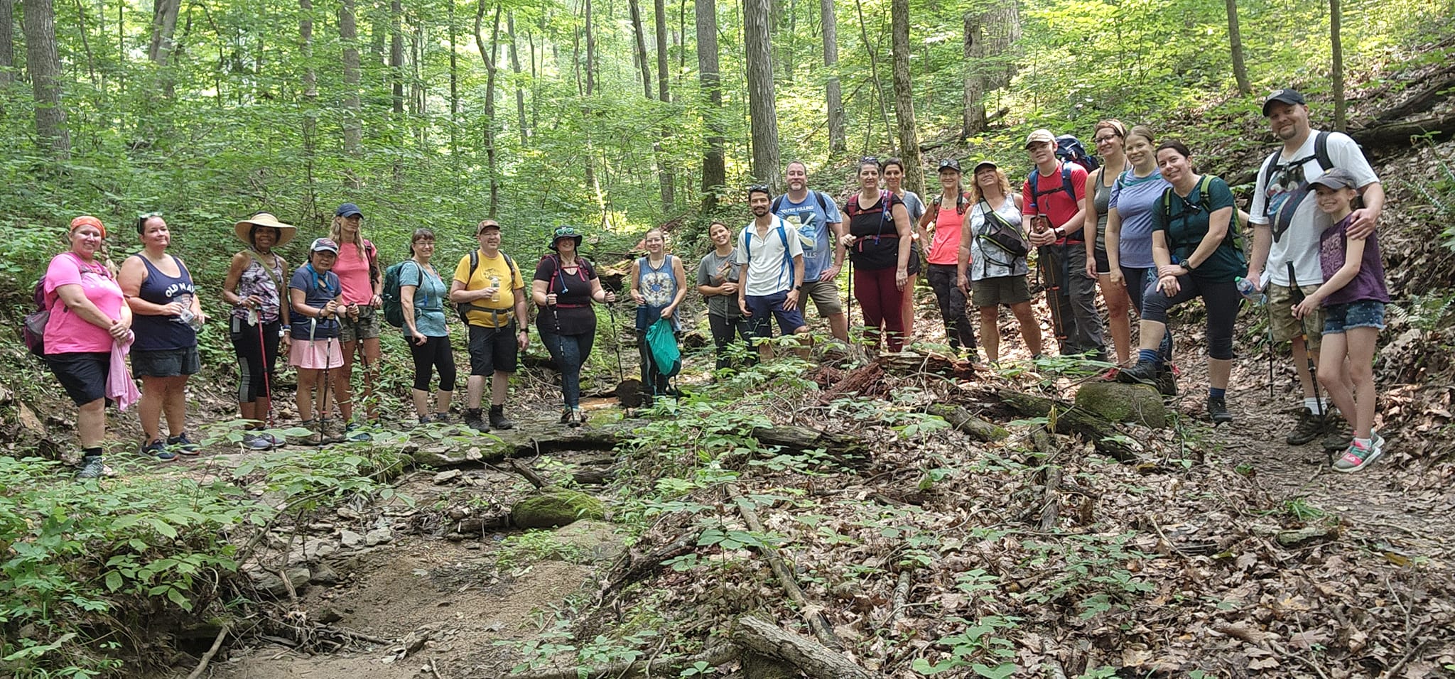 Group of hikers in the woods standing in a semi-circle