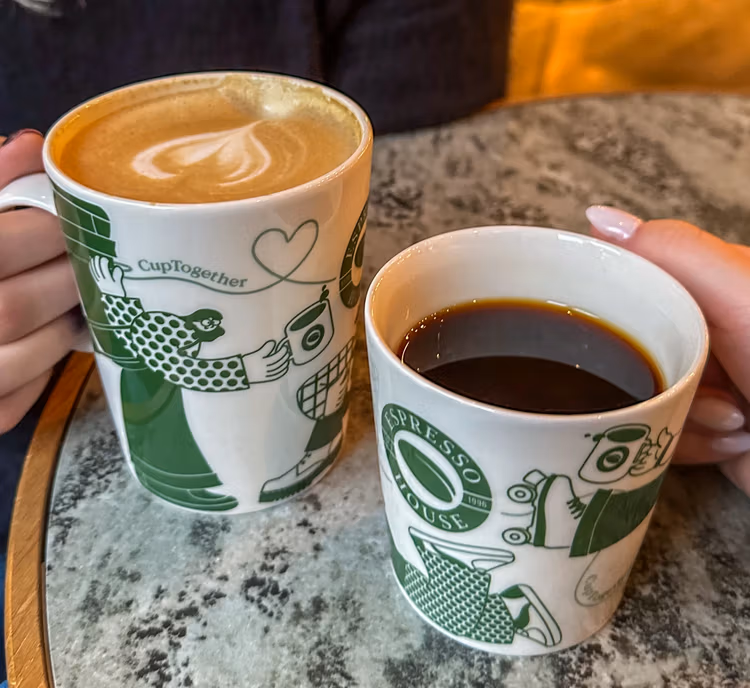 090225 CupT03 png Two coffee cups with green images of people connecting.